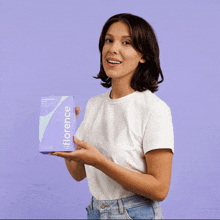 a woman is holding a box of florence products