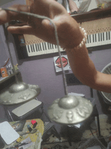 a person is holding a pair of cymbals in front of a stop sign on the wall