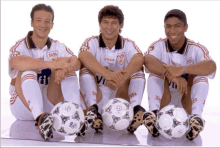 a group of soccer players are posing for a photo with their feet on soccer balls