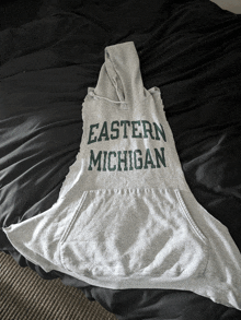 an eastern michigan sweatshirt sits on a bed