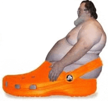 a fat man is wearing a large orange crocs shoe .