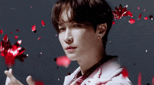 a close up of a person 's face with petals falling around him