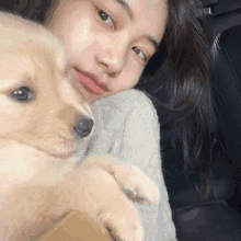 a woman is holding a small puppy in her lap .