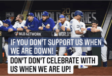 a group of baseball players sitting in a dugout with a sign that says mlb