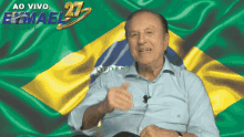 a man is sitting in front of a brazilian flag with the words ao vivo emael 27