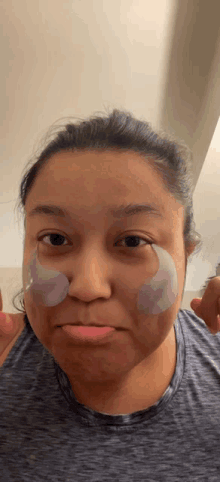 a woman with purple patches on her face making a face