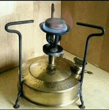 an old fashioned brass stove with a burner on top of it