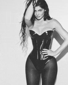 a black and white photo of a woman in a latex corset