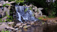 a waterfall is surrounded by rocks and trees and has a watermark that says ' james smith ' on it