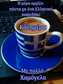 a cup of coffee sits on a blue saucer on a laptop keyboard