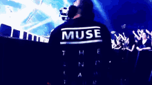 a man wearing headphones and a shirt that says muse