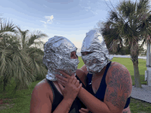 two people with aluminum foil on their heads are hugging