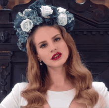 a woman wearing a crown of blue and white roses on her head