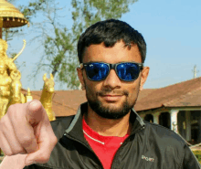 a man wearing sunglasses and a jacket that says sport on it