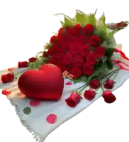 a bouquet of red roses and a red heart on a white blanket