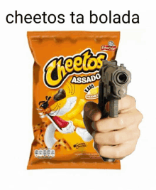 a person is holding a gun next to a bag of cheetos .