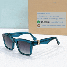 a pair of burberry sunglasses sits next to a cardboard box