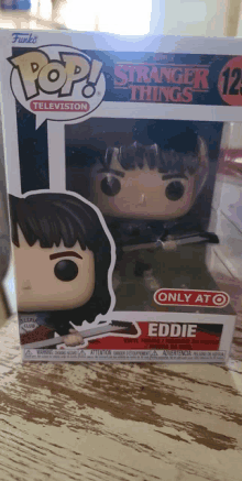 a funko pop of eddie from stranger things sits on a table