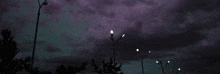 a row of street lights against a cloudy sky