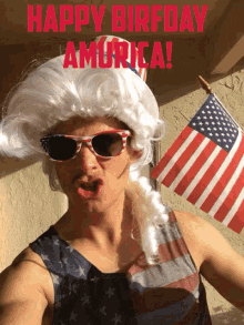 a man wearing a patriotic wig and sunglasses holds an american flag in front of a sign that says happy birthday america