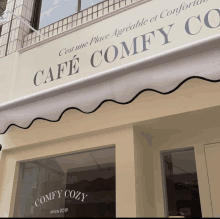 a cafe called cafe comfy cozy has a awning