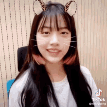 a girl wearing a cat ear headband looks at the camera .