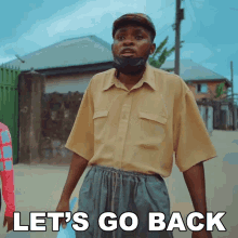 a man wearing a mask is standing in front of a sign that says " let 's go back "