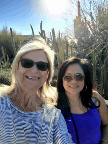 two women wearing sunglasses and a nike tank top smile for a picture