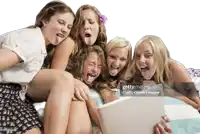 a group of girls sticking their tongues out and looking at a tablet