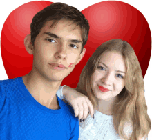 a man and a woman are posing for a picture with a red heart behind them