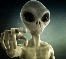 a close up of an alien pointing at the camera with his finger .