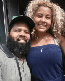 a man with a beard and a woman with curly hair are posing for a photo