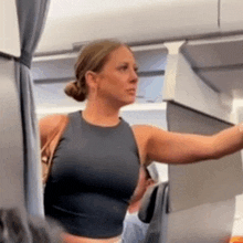 a woman in a crop top is standing on a plane .