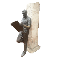 a statue of a man reading a book leaning against a stone wall