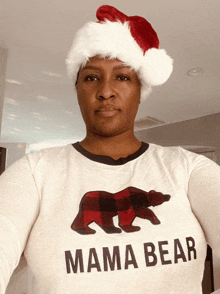 a woman wearing a santa hat and a mama bear sweater