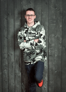 a man wearing a camo hoodie with outlaw written on it