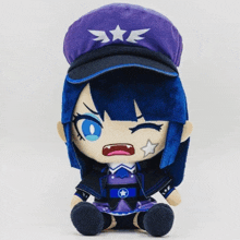 a stuffed doll wearing a purple hat with three stars