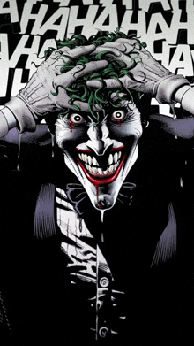 the joker is holding his head with his hands while laughing .