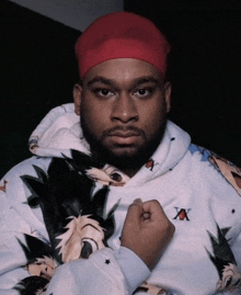 a man wearing a red hat and a hoodie with a x on it