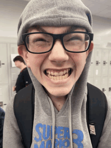 a boy wearing glasses and a super mario shirt makes a funny face