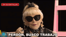 a woman wearing sunglasses and a feathered headband says " perdon busco trabajo "