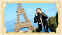 a woman in a leather jacket stands in front of the eiffel tower in a frame that says paris on it