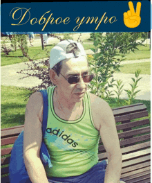 a man wearing a green adidas tank top sits on a park bench