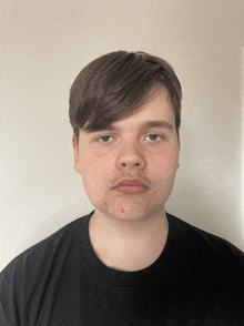 a young man wearing a black shirt has a serious look on his face