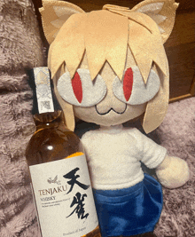 a bottle of tenjuku whisky sits next to a stuffed animal