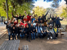 a group of people are posing for a picture with their hands in the air