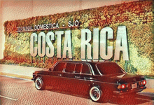 a black car is parked in front of a costa rica sign