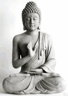 a statue of a buddha is sitting in a lotus position with his hands folded in prayer .