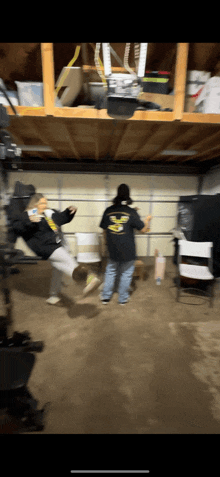 a man and a woman are dancing in a garage with the man wearing a black shirt with the number 8 on the back .