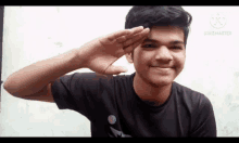 a young man salutes with his hand over his face